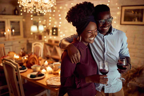 a couple in front of the dining table full of food